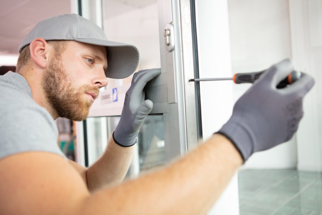 cheerful locksmith installing a door lock