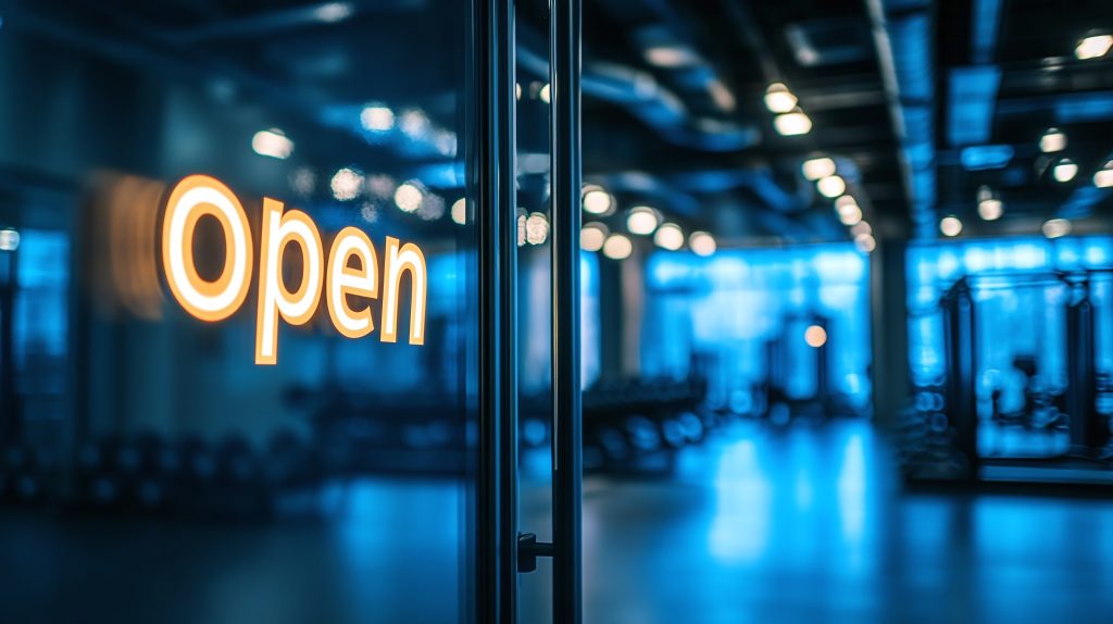 Closeup text "open" on the gym building with glass door, indoor workout club outdoors look, entrance inside, into a training center room.