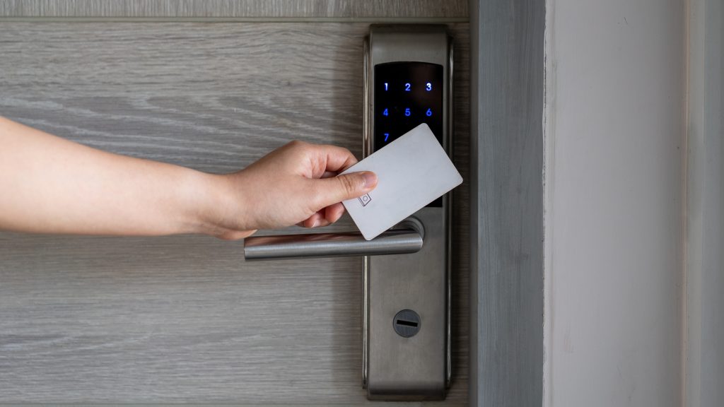 Electronic card key for open door in hotel. Smart card key to lock and unlock door. Security systems and protection concept.