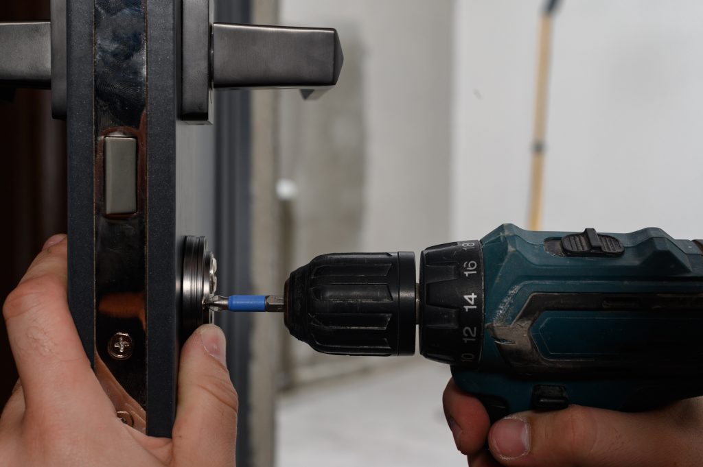 Installation of lock and door handle to interior doors, locksmith works with doors.