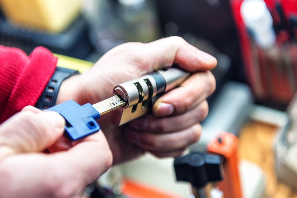 locksmith is testing door lock cylinder